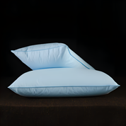 Two light blue pillows on a dark surface