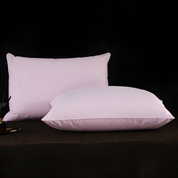 Two pink pillows on a dark surface with a black background